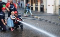 De jeugdbrandweer leert kinderen hoe ze een brandslang moeten vasthouden